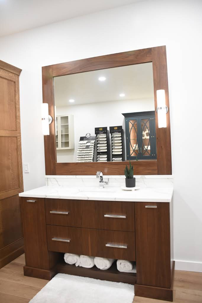 Wood bathroom vanity and coordinating framed mirror in the Elite Kitchens showroom