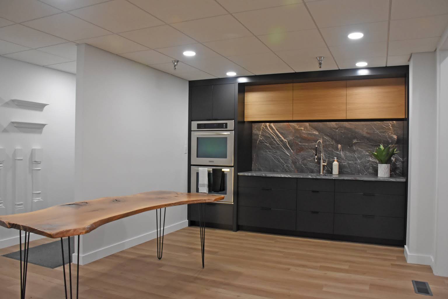 Contemporary dark cabinetry, wood accents, and dramatic stone in the Middlebury showroom