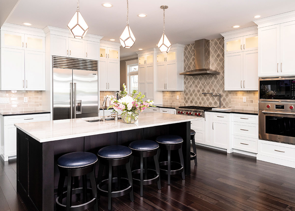 Kitchen designed by Elite Kitchens in Middlebury, featuring white cabinetry and a contrasting dark island